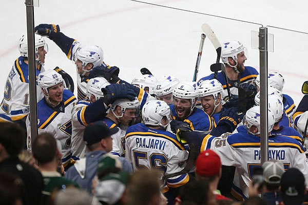 Blues left wing Magnus Paajarvi (center) is swarmed with his teammates after scoring the game-winning goal during overtime Saturday in Game 5 of a Western Conference first-round playoff series against the Wild in St. Paul, Minn. St. Louis won the game 4-3 and the series 4-1.