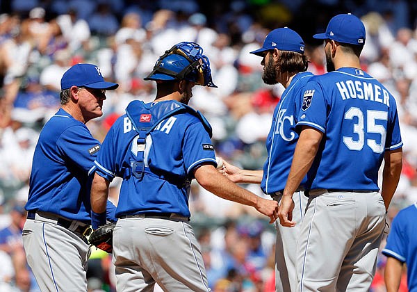 Royals manager Ned Yost (left) takes the ball from starting pitcher Jason Hammel (second from right) in the fourth inning of Sunday afternoon's game against the Rangers as Drew Butera and Eric Hosmer stand on the mound in Arlington, Texas.