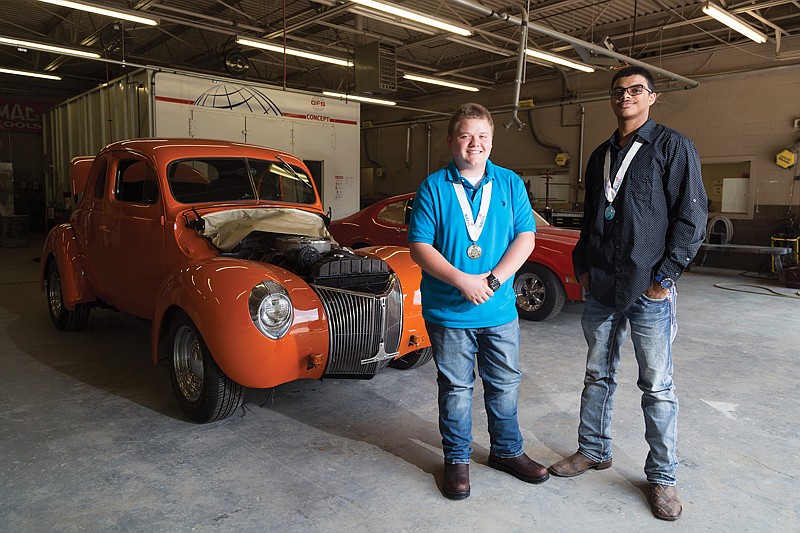 Jared Hill and Cortland Adcock stand next to a 1940 Ford Coupe and a 1973 Ford Maverick Friday at Arkansas High School. The two students brought home gold and silver awards from the SkillsUSA automotive refinishing competition April 11 in Hot Springs, Ark.
