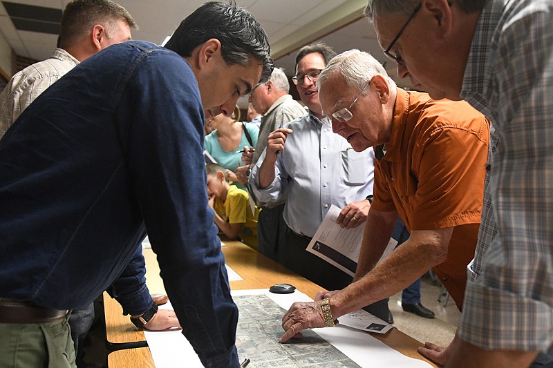 Texas Department of Transportation District Bridge Engineer Glenn Yowell, left, discusses the details of the upcoming McKnight Road expansion project with local resident Delton Gwinn, right, during a public meeting with TxDOT Monday at Pleasant Grove High School.
