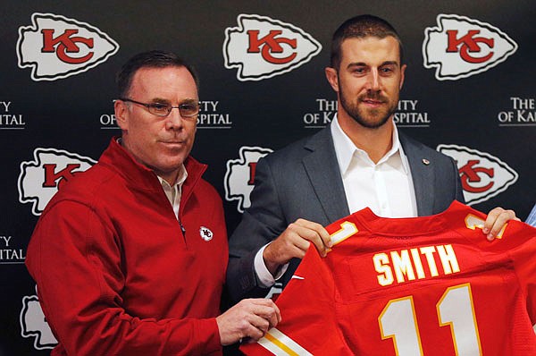 In this March 13, 2013, file photo, Chiefs general manager John Dorsey stands with newly signed quarterback Alex Smith following a news conference at the team's practice facility in Kansas City. Smith is firmly entrenched as the starter in Kansas City and Dorsey is firmly in his corner.