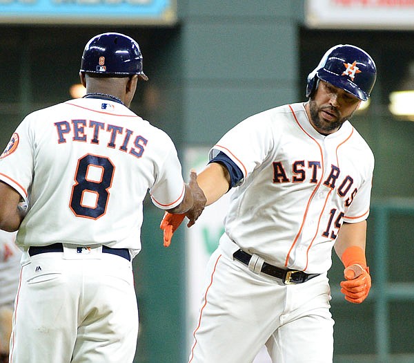 Carlos Beltran of the Astros is congratulated by third base coach Gary Pettis after hitting a solo home run against the Angels last Thursday in Houston.