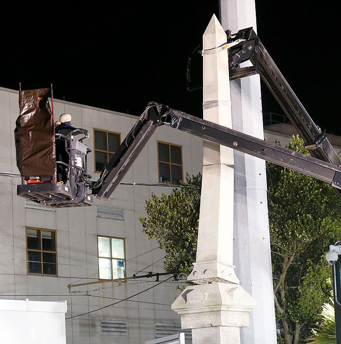 Workers dismantle the Liberty Place monument, which commemorates whites who tried to topple a biracial post-Civil War government in New Orleans. It was removed overnight Monday in an attempt to avoid disruption from supporters who want the monuments to stay.