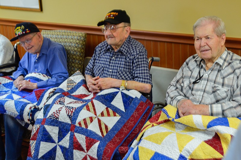 World War II veterans, from left, Joe Carrington, Chris Binggeli and Woodrow Boulware received their personalized Quilts of Valor at Fulton Presbyterian Manor on Monday. Quilts of Valor is a organization started in 2003 to provide an object of healing and comfort for veterans.
