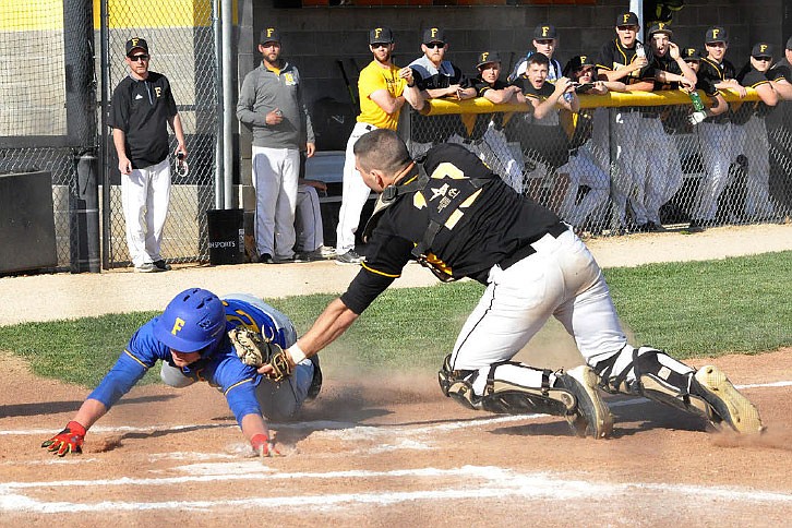 Fulton senior catcher Isaiah Pani tags out a Fatima base runner at home plate to end the top of the third inning in the Hornets' 4-1 win over the Comets — ranked No. 7 in Class 3 — on Monday night, April 24, 2017 at the high school athletic complex.