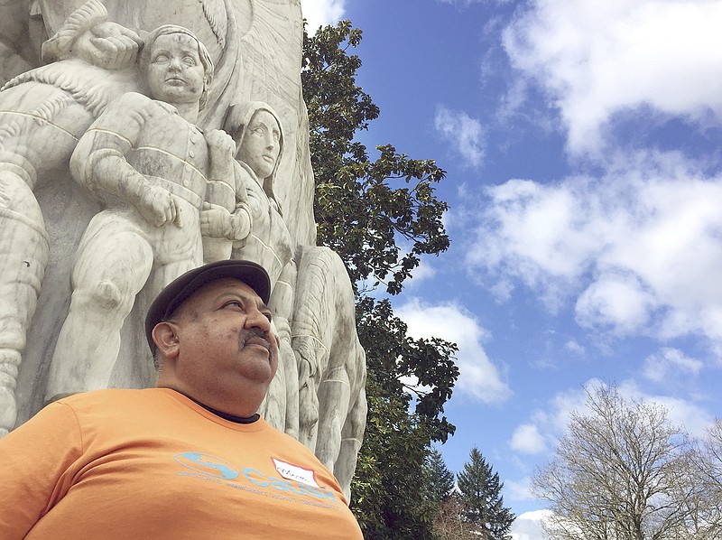 Moses Maldonado poses for a photo March 30 in front of a statue depicting pioneers in front of the Oregon Capitol in Salem. Maldonado, who attended a rally honoring farmworker organizer Cesar Chavez at the Oregon statehouse, is a 50-year-old undocumented farmworker who says he is afraid he will be picked up by federal immigration authorities when he leaves his house to go to the fields.