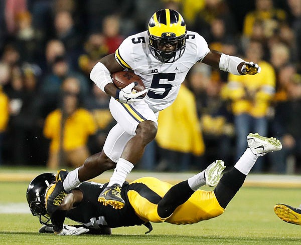 In this Nov. 12, 2016, file photo, Michigan's Jabrill Peppers breaks a tackle by Iowa defensive back Desmond King during the first half of a game in Iowa City, Iowa.