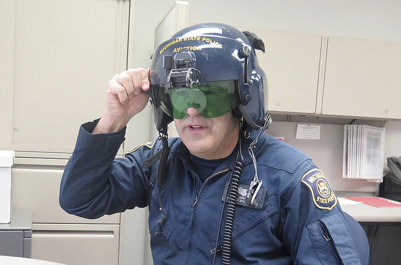Michigan State Police pilot Jerry King, shows an anti-laser shield March 14 in his office at a state police facility at Capital Region International Airport, in Lansing. Pilots use the anti-laser shield on their helmet when they are trying to pinpoint the source of a laser that is being shined at them or other aircraft. Michigan is poised to join a growing list of states and enact its own stiff law criminalizing increasingly frequent laser attacks that are endangering pilots and their passengers.
