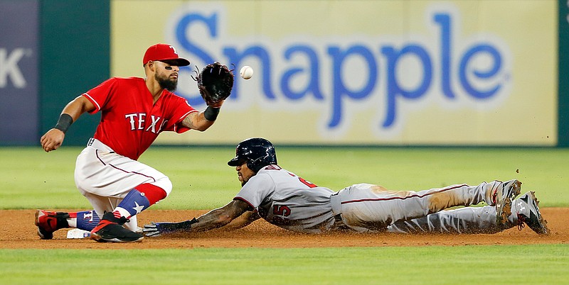 Texas Rangers second baseman Rougned Odor reaches up for the throw to the bag as Minnesota Twins' Byron Buxton steals second during the fourth inning of a baseball game in Arlington, Texas, Tuesday, April 25, 2017.