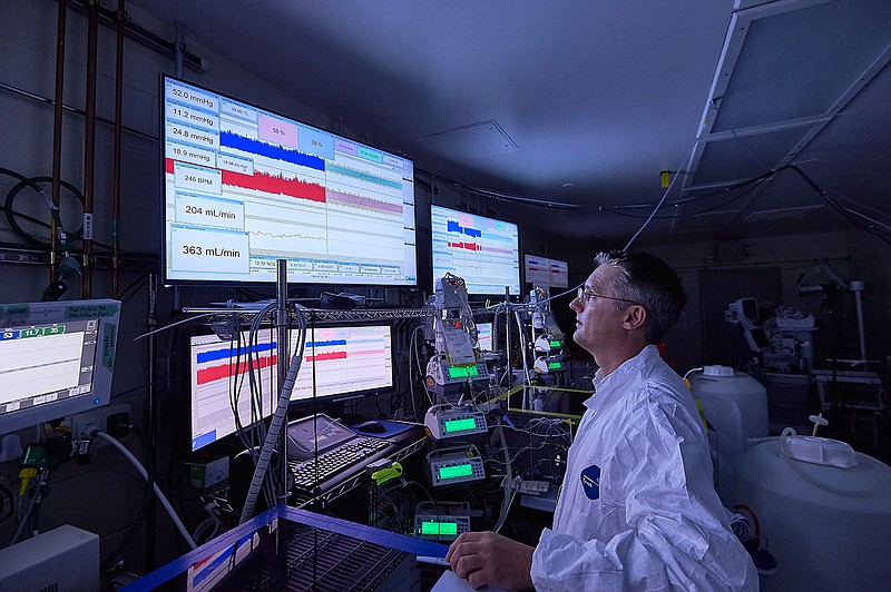 In this photo provided by the Children's Hospital of Philadelphia, fetal physiologist Marcus G. Davey of the Children's Hospital of Philadelphia, who helped design the artificial womb system. He is shown near giant tanks holding a liquid designed to simulate amniotic fluid. Researchers are creating an artificial womb to improve care for extremely premature babies, and animal testing suggests the first-of-its-kind watery incubation so closely mimics mom that it just might work. 