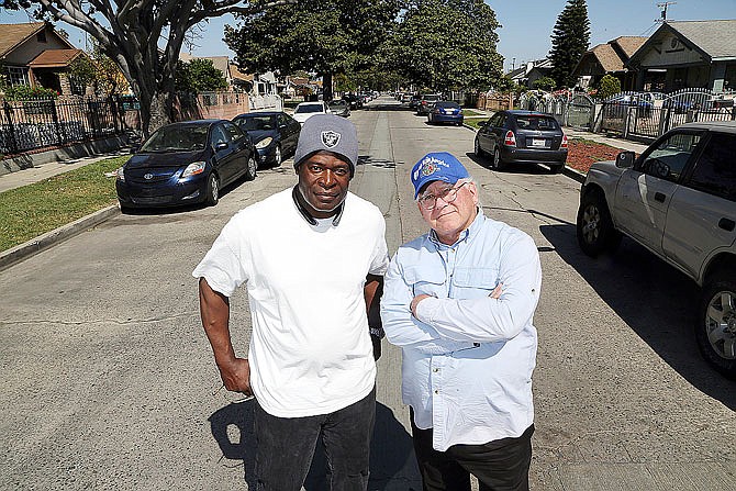 Bart Bartholomew, right, who in 1992 was photographing the riots that erupted in Los Angeles after the acquittal of police officers in the Rodney King beating trial, stands with Tim Goldman, a videographer who helped Bartholomew escape when the crowd they were both covering turned violent, on 71st Street east of Normandie in South Los Angeles.