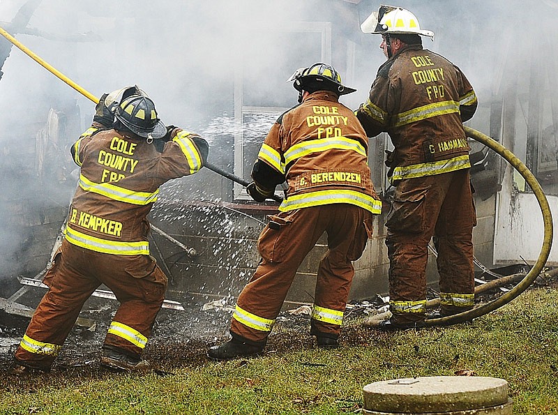 In this Nov. 10, 2014 file photo, firefighters from the Cole County Fire Protection District work to extinguish a smoldering house fire in the county.