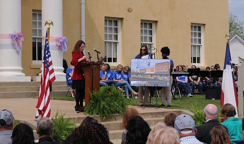 Cecilia Abbott speaks at the Cass County Courthouse at the unveiling of an artist's conception of how the west side of the square might look under the Main Street program. The art work can be seen at Linden City Hall.