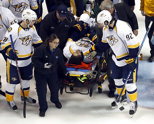 Nashville Predators' Ryan Johansen (92) and Viktor Arvidsson, left, of Sweden, offer encouragement to teammate Kevin Fiala, of Switzerland, as Fiala is taken off on a stretcher after being injured during the second period in Game 1 of an NHL hockey second-round playoff series against the St. Louis Blues, Wednesday, April 26, 2017, in St. Louis.