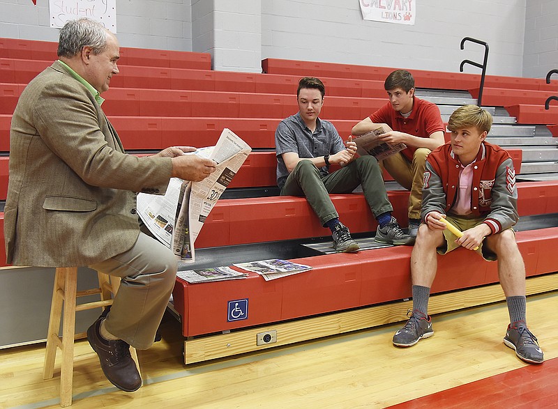 Using current events in the News Tribune, Pastor Jeff Schanbacher, left, interacts with Calvary Lutheran High School students, from left, Alex Flannigan, Drew Goodin and Luke Allen as they participated in Wednesday's Witness Workshop.