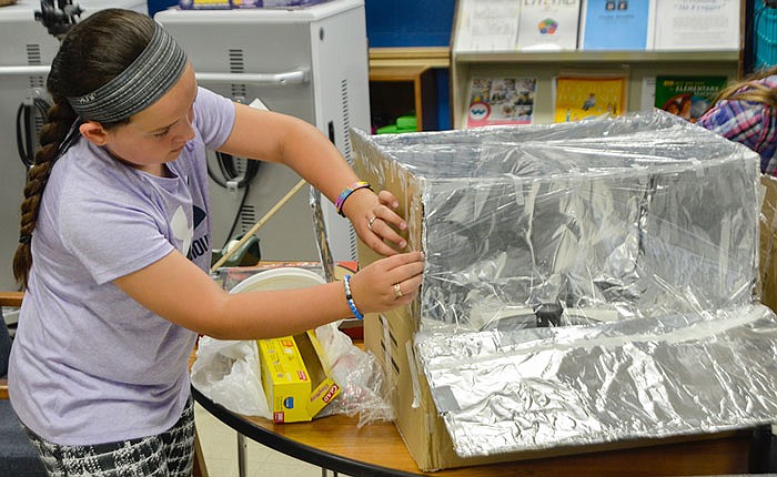 South Callaway student Reagan Arrowood makes some adjustments to her solar oven.