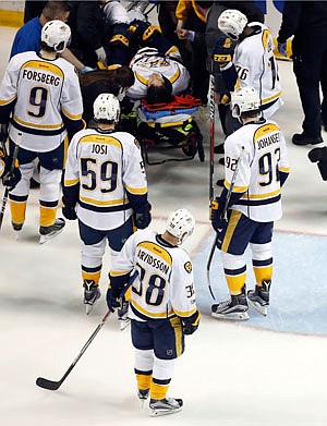 Teammates watch as Kevin Fiala of the Predators is taken off on a stretcher during the second period of Wednesday night's game against the Blues in St. Louis.