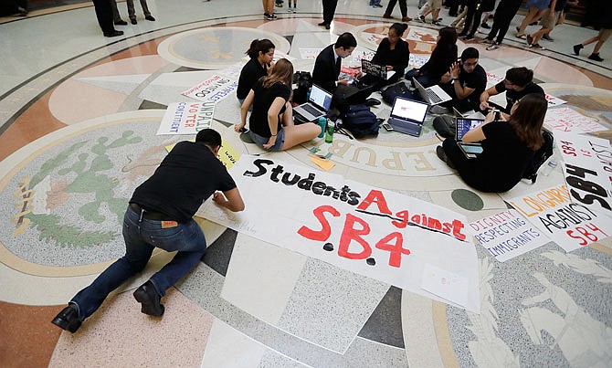 Students gather Wednesday in the Rotunda at the Texas Capitol to oppose SB4, an anti-"sanctuary cities" bill that already cleared the Texas Senate and seeks to jail sheriffs and other officials who refuse to help enforce federal immigration law, as the Texas House prepares to debate the bill in Austin, Texas.  