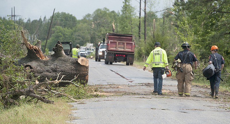 Workers clear trees blown down on roads and power lines Thursday along Stowers Road in Montgomery County, Alabama, following morning storms.