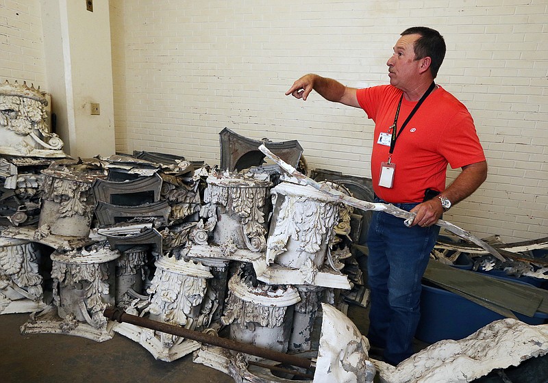 In this April 13, 2017 photo, Building Facilities Director Herschel Miller examines some of 115-year-old zinc relics that originally adorned the historic McLennan County Courthouse dome in Waco, Texas,  located in a plain room whose location won't be revealed. The ornaments are irreplaceable and rich in sentimental value, county officials keep the storage location close to the vest. 