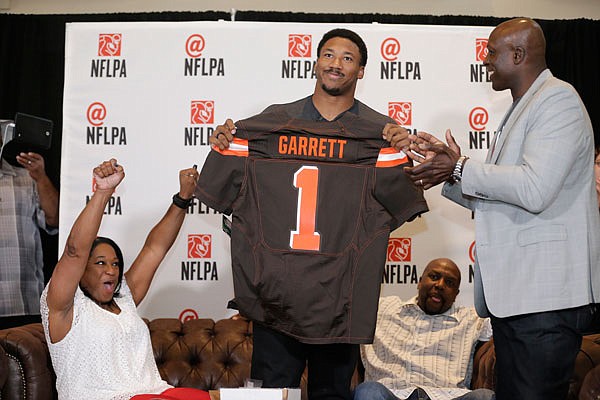 In a photo by the NFLPA, former No. 1 overall pick Bruce Smith (right) presents a Cleveland Browns jersey to Myles Garrett while his mother Audrey (left) and father Lawrence look on at the NFL Players Association's Myles Garrett Draft Day party Thursday in Arlington, Texas.