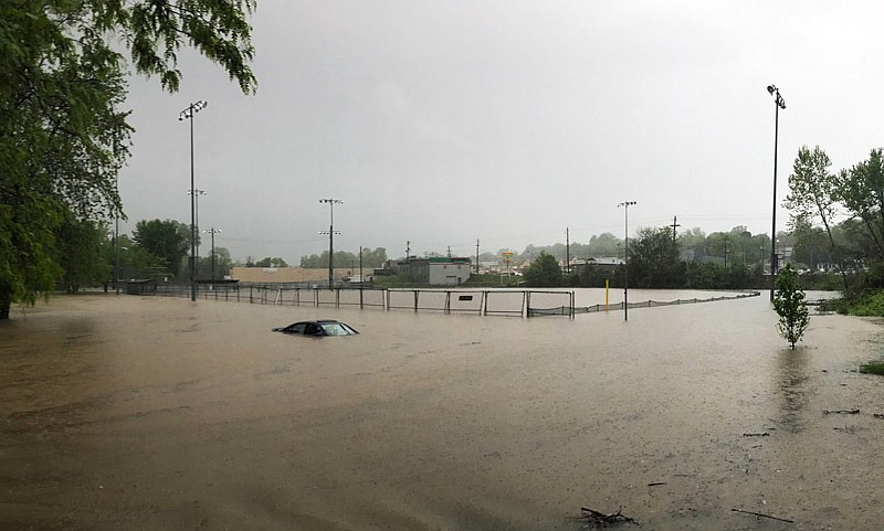 A parked car is submerged in rain water during flash flooding at Washington Park on Saturday, April 29, 2017. A Washington Park staff member assisted the owner out of her car after she got stuck attempting to drive through the water.