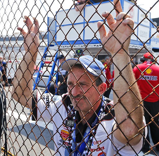 A Dale Earnhardt Jr., fan watches the pit crew from the other side of a fence in the garage after practice for Sunday's NASCAR Cup Series auto race at Richmond International Raceway in Richmond, Va., Saturday, April 29, 2017. 