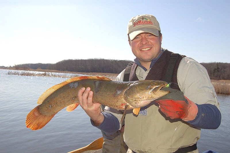 Brandon Butler holds his National Fresh Water Fishing Hall of Fame, catch and release, fly fishing, 20-pound tippet class world record bowfin.