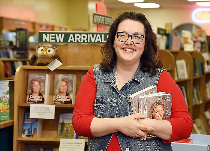 Kelly Smith poses in Downtown Book and Toy with copies of the Chicken Soup series of books featuring one of her essays.