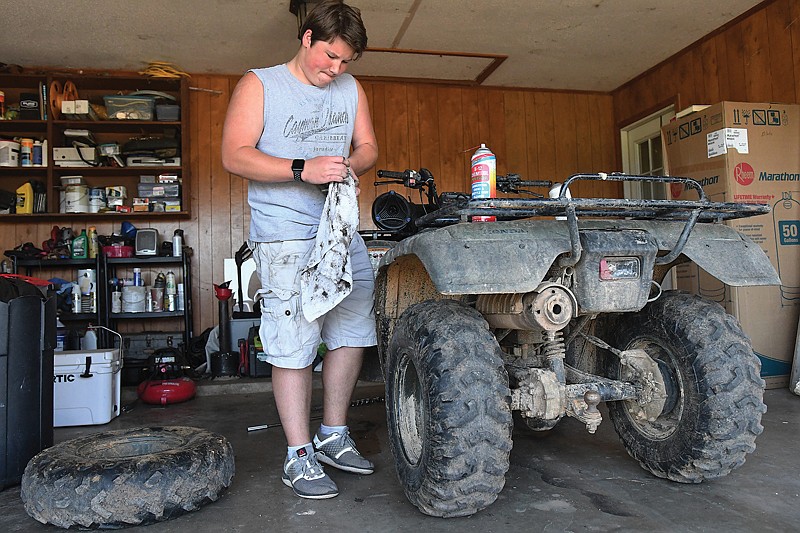 Taylor Campell takes advantage of the cool and comfortable day to work on his 4-wheeler Monday at his home on North Sanderson Lane in Texarkana, Ark. Today's weather will be sunny and warmer, with a high near 86. See Page 6A for the full five-day weather forecast.