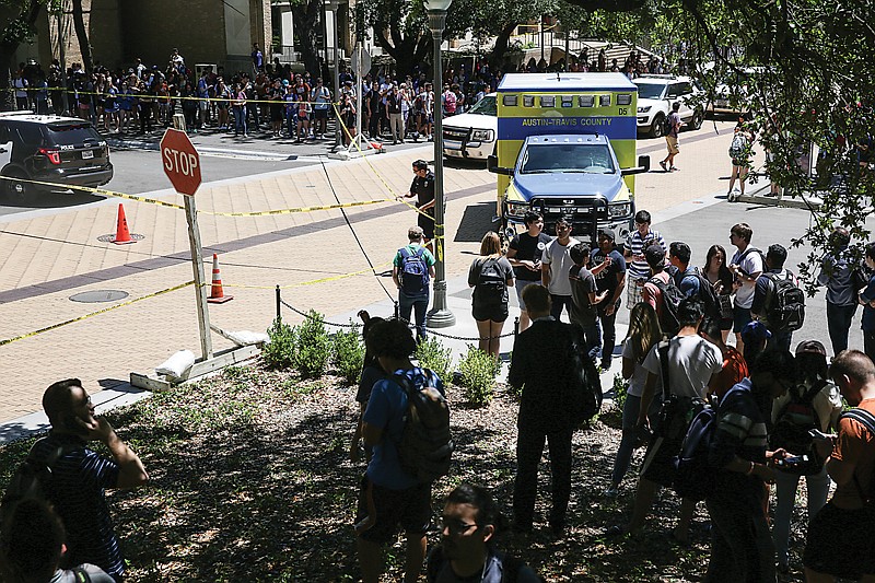 Law enforcement officers secure the scene after a stabbing attack that left one dead, three wounded Monday on the University of Texas campus in Austin. Police say a suspect is in custody.