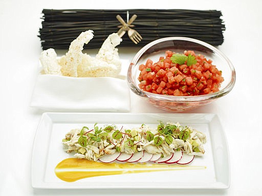 This April 24, 2017 photo provided by The Culinary Institute of America shows an avocado and crab salad garnished with sliced radish and citrus-mango sauce, foreground, a chilled watermelon salad, right, and deep fried rice crisps, left, in Hyde Park, N.Y. (Phil Mansfield/The Culinary Institute of America via AP)