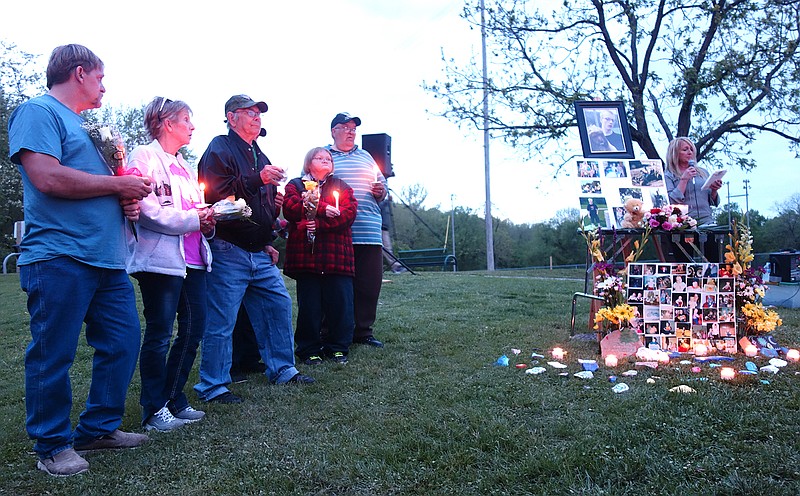 While search organizer Shellea Young, far right, spoke, Carl DeBrodie's family stood close together holding flowers and candles. Those present included stepfather Larry Summers, right, aunt Carol Samson, second from left, brother Nicolas Clark and many others.