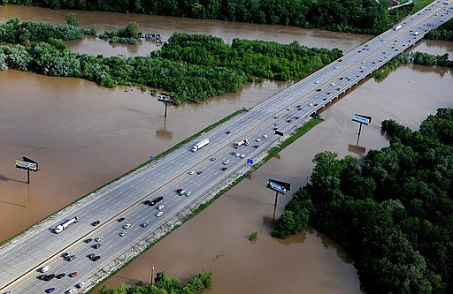 In this Tuesday, May 2, 2017 photo, traffic flows freely as floodwaters escape the banks of the Meramec River as it intersects with Interstate 55 just north of Arnold, Mo. The highway's southbound lanes were closed when floodwaters rose but reopened on Thursday.