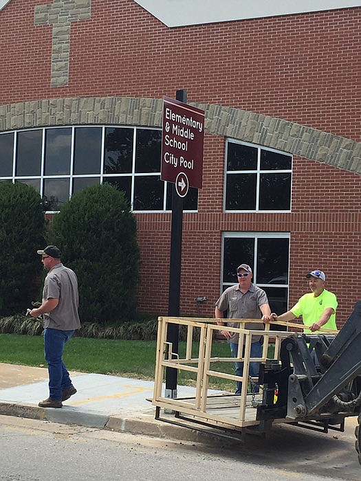 City street department employees install new wayfinding signs provided by California Progress Inc.