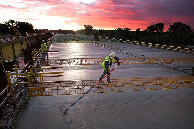 A Jensen Construction Co. crew member uses a bull float Tuesday morning to finish the concrete on the deck of the new Interstate 30 bridge over Red River near Fulton, Ark. The Arkansas Highway Department has two projects being completed simultaneously on I-30 east of Texarkana. The projects stretch from mile marker seven to mile marker 18. Work began on the bridge section of the project in Aug. 2015 with an estimated completion date of Oct. 2017. The combined total for the two jobs is $49,800,492.93 