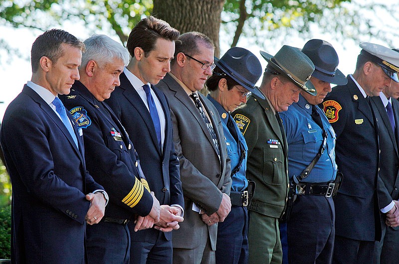 Missouri Gov. Eric Greitens, left, bows his head in prayer along with other state and city officials during the Law Enforcement Memorial service Saturday, May 6, 2017 on the north lawn of the state Capitol.