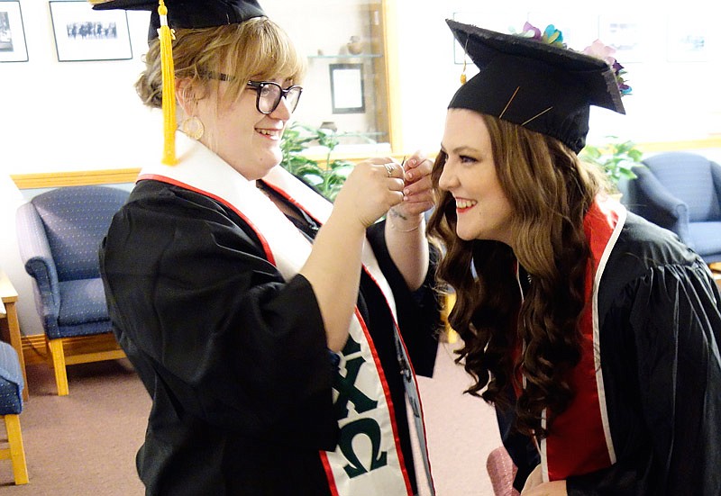 Best friends and fellow graduates Shelby Dorfman (left), of Chicago, help Lauren Yelton, of Fort Worth, Texas, with her cap before graduation at William Woods University on Saturday, May 6, 2017.