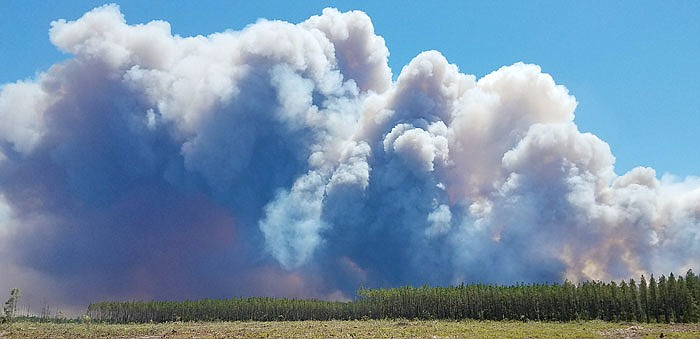 In this photo provided by the Okefenokee National Wildlife Refuge smoke rises from a wildfire east of Fargo, Georgia. Firefighters were battling Sunday to prevent the fire from spreading, authorities said.