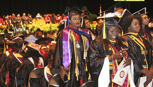 Some Bethune-Cookman University graduates, seen at left, turn their backs as U.S. Secretary of Education Betsy DeVos, delivers the commencement address to the graduates at the Ocean Center in Daytona Beach, Fla., Wednesday, May 10, 2017. Drawing shouts of "Liar!" and "Just go," DeVos powered through her commencement address Wednesday at the historically black university, even as many of the graduating students turned their backs to her in protest. (David Tucker/The Daytona Beach News-Journal via AP)