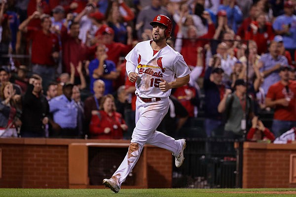 Cardinals right fielder Randal Grichuk scores on a wild throw to first base after Kolten Wong struck out during the ninth inning of Friday night's game against the Cubs at Busch Stadium in St. Louis.