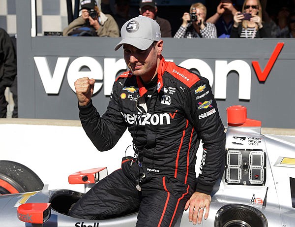 Will Power celebrates as he climbs out of his car Friday after winning the pole for the IndyCar Grand Prix at Indianapolis Motor Speedway in Indianapolis.