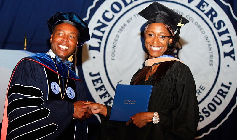 Nessa Paul receives her master's in business degree from outgoing Lincoln University President Kevin Rome on Saturday, May 13, 2017.