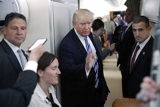 President Donald Trump gestures after speaking to members of the media aboard Air Force One before his departure from Andrews Air Force Base, Md., Saturday, May 13, 2017. 