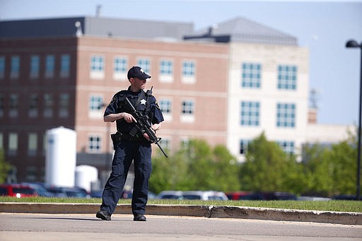 A Kane County police officer monitors the scene at Northwestern Medicine Delnor Hospital in Geneva, Ill., during a lockdown after a jail inmate being treated there managed to take a correctional officer's gun in the facility and hold an employee hostage, Saturday, May 13, 2017. (Chris Sweda/Chicago Tribune via AP)