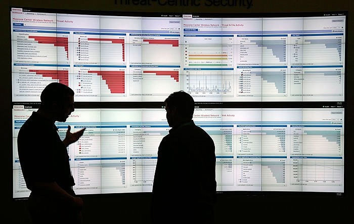 Stijn Vanveerdeghem, left, an engineer with Cisco, shows graphics with live wireless traffic to FedEx employee Barry Poole in May 2017 during the RSA Conference in San Francisco, where threat analysts, security vendors and corporate IT administrators gathered to talk about malicious software, spear-phishing and other attacks that can steal money or secrets from companies and consumers.