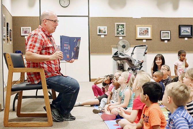 Eric Lyon reads to children Tuesday during preschool story time at the Missouri River Regional Library.
