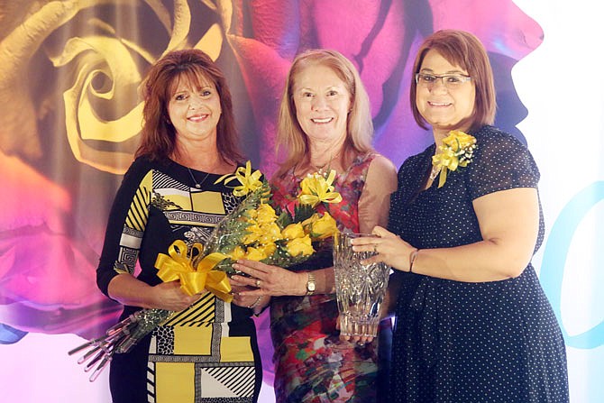 Sherri Elliott-Thomas, left, is presented with the 2017 Women of Achievement Award during the Zonta Women of Achievement Yellow Rose Luncheon Tuesday at Capitol Plaza Hotel. Elliott-Thomas was one of two women presented with the award.