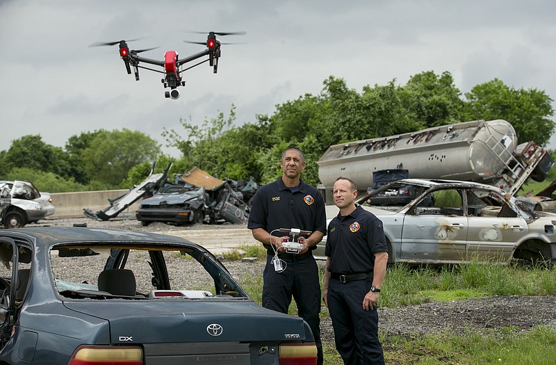 In a Thursday April 20, 2017 photo, Austin Fire Department Capt. Greg Pope, left, and firefighter Coitt Kessler demonstrate flying a DJI Inspire 1 drone at the Austin Fire Department Training Academy in Austin, Texas. Austin police aren't pursuing a drone program in any official capacity. However, the Austin police union is researching the technology and pushing for drones to be used by the department.