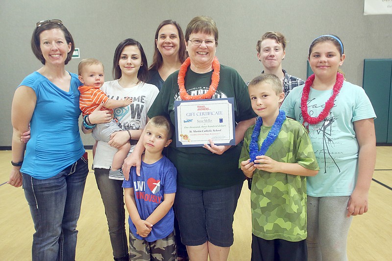 Susan Meller, center, poses for a picture with her family after being presented with a travel gift certificate in honor of her retirement from St. Martin Catholic School in Jefferson City on Tuesday, May 16, 2017. 